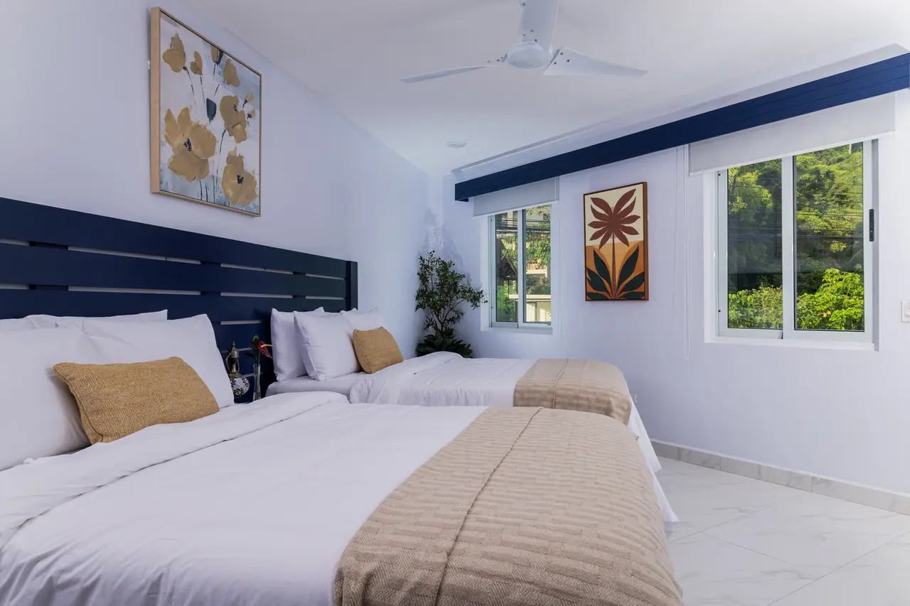 Pacific Suite bedroom with two queen beds and tropical artwork