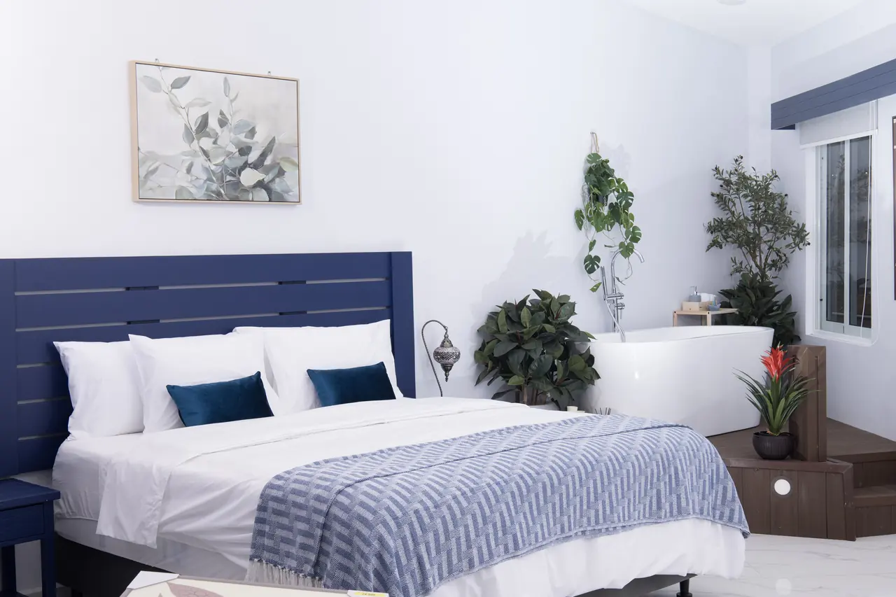 Serenity Suite king bed with blue headboard and tropical plants