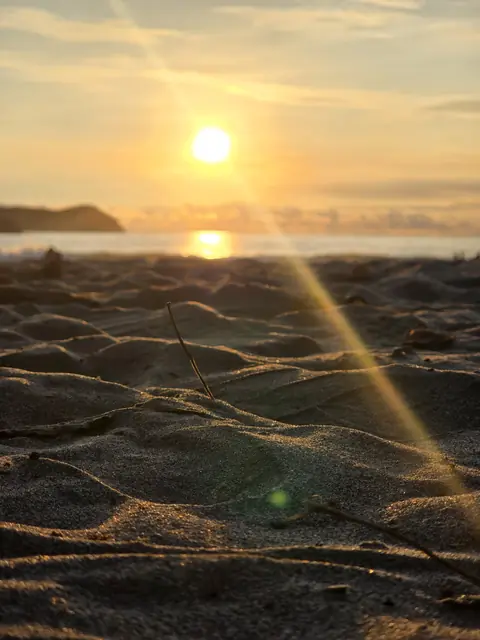 Sun setting over the sand on the beach