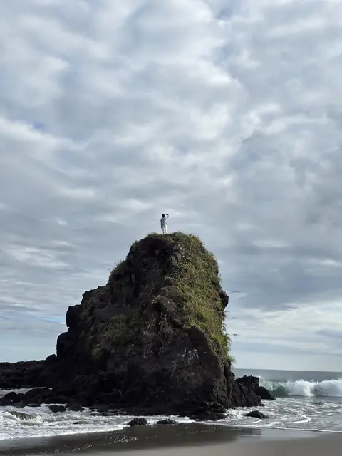 Rock formation by the sea under a cloudy sky