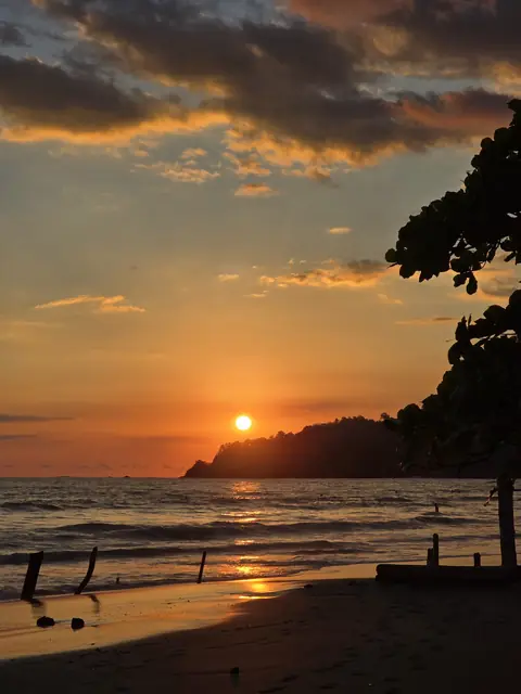 Golden sunset behind a rocky point on the beach