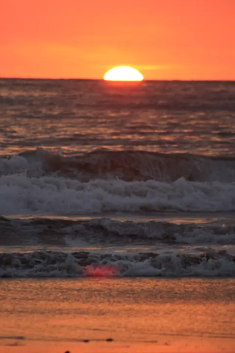 Sun setting over the ocean waves