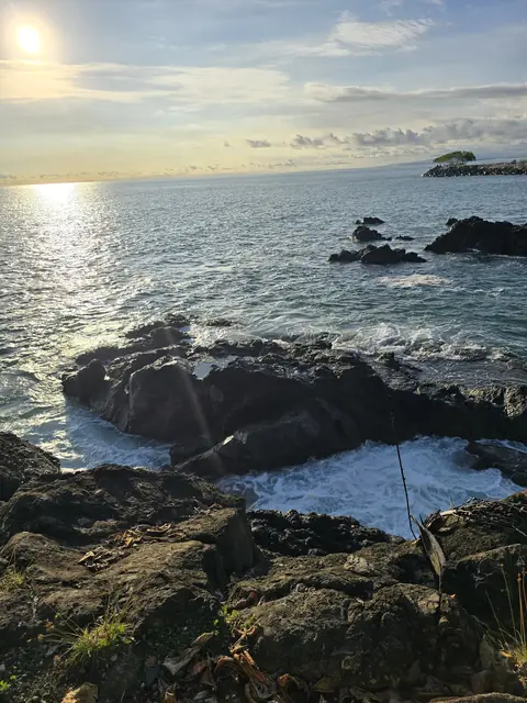 Sun glare over rocks and the sea